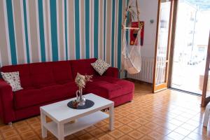 a living room with a red couch and a table at A casa di Filo in Boiano