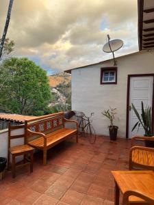 a patio with a bench and tables and a building at Pousada Solar das Gerais in Ouro Preto