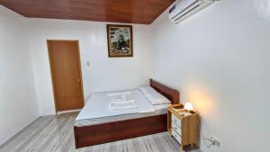 a small bedroom with a bed and a night stand at VAL Homestay in Siquijor
