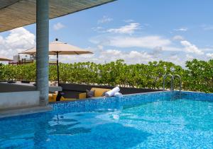a swimming pool with chairs and an umbrella at The Sands Boutique Condos in Playa del Carmen