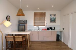 a kitchen with white cabinets and a table with chairs at BoraBora Lagoon View lodge in Bora Bora