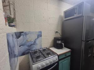 a kitchen with a stove and a refrigerator at Backpacker's ROOF in San Salvador