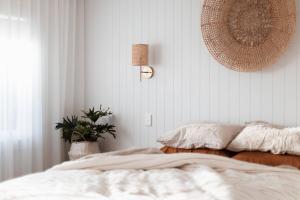 a bedroom with a bed and a potted plant at Antalya Beach House in Bridport +7 photos