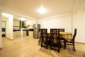 a kitchen and dining room with a table and chairs at Departamento para 14 personas Cusco in Cusco