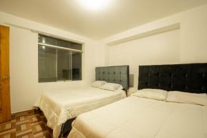 a room with two beds and a window at Departamento para 14 personas Cusco in Cusco