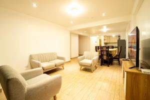 a living room with chairs and a flat screen tv at Departamento para 14 personas Cusco in Cusco