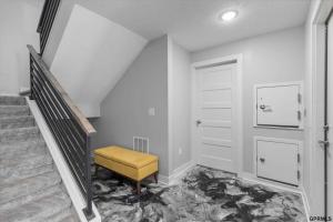 una scala con uno sgabello giallo accanto a una porta di Midtown Luxury - 2 Master Suites - Near UNMC a Omaha