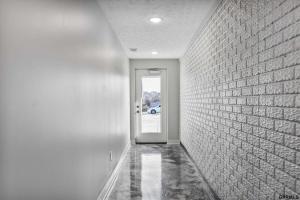 un corridoio con un muro di mattoni e una porta di Midtown Luxury - 2 Master Suites - Near UNMC a Omaha Altre 21 foto
