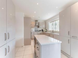 a white kitchen with white cabinets and white appliances at Carey in Eastchurch