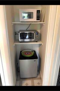 a small kitchen with a microwave and a trash can at Cottage Apartment by Lake MI w private Hot Tub!  +8 photos