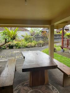 two wooden benches sitting under a pavilion with a view at Umah Lumbung Estetik in Tanah Lot