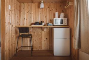 a kitchen with a counter with a refrigerator and a microwave at yogahouse in Mine