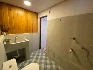 a bathroom with a toilet and a sink and a shower at The River Villa in Talpe