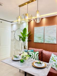 a dining room with a table and a couch at 2-Bedroom Cozy Haven Sorrento Oasis in Manila