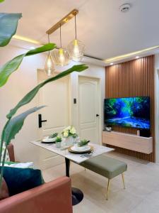 a living room with a table and a tv at 2-Bedroom Cozy Haven Sorrento Oasis in Manila
