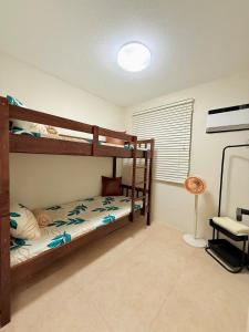 a bedroom with two bunk beds and a lamp at 2-Bedroom Cozy Haven Sorrento Oasis in Manila