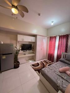 a bedroom with a bed and a tv at Sunvida Tower staycation unit 2503-2504 in Cebu City