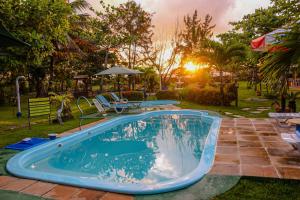 una piscina en un patio con mesa y sillas en Vila dos Ventos - RedeVilla, en Estância