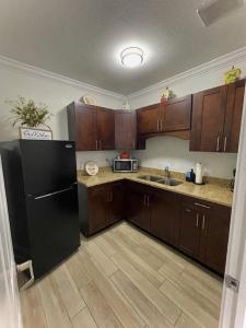 タンパにあるEl Palacioのキッチン(黒い冷蔵庫、木製キャビネット付)