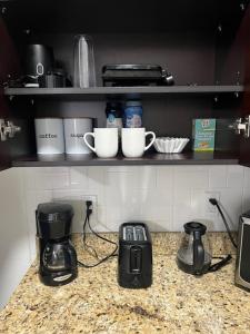 a kitchen counter with cups and appliances on a shelf at El Palacio in Tampa