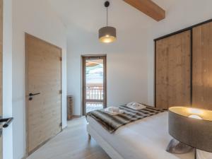 a bedroom with a bed and a large window at Appartement moderne aux pieds des pistes, Alpe d'Huez - FR-1-645-92 in L'Alpe-d'Huez