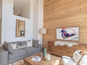 a living room with a couch and a tv on a wall at Appartement moderne aux pieds des pistes, Alpe d'Huez - FR-1-645-92 in L'Alpe-d'Huez