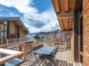 a wooden deck with a table and chairs on it at Appartement moderne aux pieds des pistes, Alpe d'Huez - FR-1-645-92 in L'Alpe-d'Huez