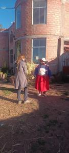 two children standing in front of a brick building at Hotel INKAS WATANA LODGE in Acora +5 photos