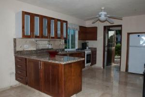 a kitchen with wooden cabinets and a counter top at MoonLight Condos in Puerto Morelos