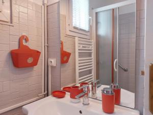 a bathroom with a sink with red cups on it at Gîte Saint Lubin à Cloyes : Confort familial et charme régional - FR-1-581-157 in Cloyes-sur-le-Loir +27 photos