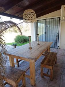 Una mesa de madera y bancos en un patio. en Posada El Descanso, en Mercedes