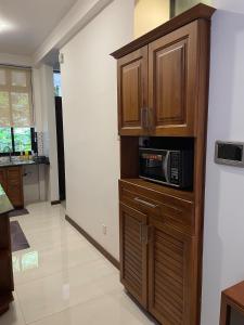 a kitchen with a microwave in a wooden cabinet at Hilltop Retreat near Kandy Lake - Kings Residence in Kandy