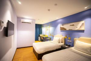 a hotel room with two beds and a desk at Le Embassy Hotel Georgetown in George Town
