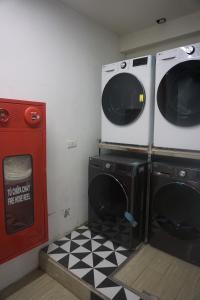 una lavanderia con due lavatrici e un pavimento a scacchi di ACE Hostel a Hanoi