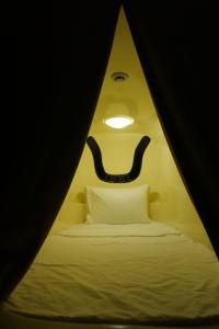 una stanza con un letto con una faccia sul muro di ACE Hostel a Hanoi