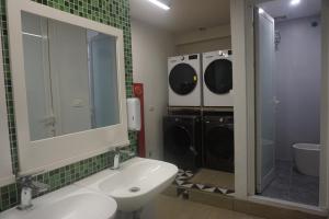 a bathroom with a sink and a washing machine at ACE Hostel in Hanoi