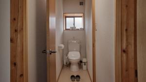 a small bathroom with a toilet and a window at Five Peaks Yudanaka in Yamanouchi +28 photos
