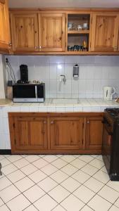 eine Küche mit Holzschränken und einer Mikrowelle in der Unterkunft Riad Nahara in Marrakesch