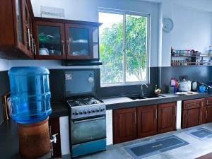 a kitchen with a stove and a window at Seven Crest Hotel Anuradhapura in Anuradhapura