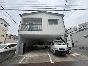 a garage with two cars parked in front of a building at 長期割がお得 最大8名 2BR 55平米 東京駅電車10分 TDR スカイツリー好アクセス 駐車場予約 送迎有 HOTEL DREAM MUSIC Tōyōchō pastel in Tokyo