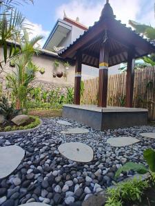 a garden with a gazebo and a stone path at Pondok Layung in Tegalalang