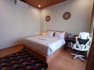 a bedroom with a bed and a desk and a chair at Pondok Layung in Tegalalang
