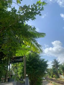 a street sign in front of a palm tree at Sri Mali Holiday Home in Pelena