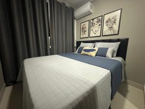 ウベルランジアにあるFlats Praia Uberlandia - Apt próximo ao Praia Clube - Area de lazer com Portaria 24 horas, piscina, academia, brinquedoteca, churrasqueira e áreas verdes para caminhadasの青と白のシーツが敷かれた大きなベッドのある寝室 +133枚の写真