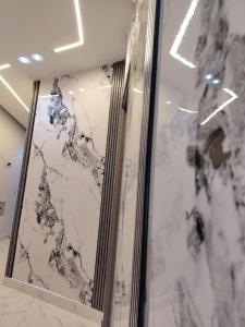 Una pared de mármol en una habitación con dos cuadros. en Experts, en Seis de Octubre