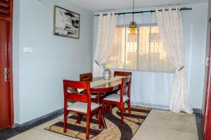 a dining room with a table and chairs and a window at NT Homes in Dar es Salaam