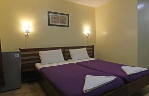 a bedroom with a bed with purple sheets and white pillows at Cherrys @ Home Too Inland Resort in Panglao +74 photos