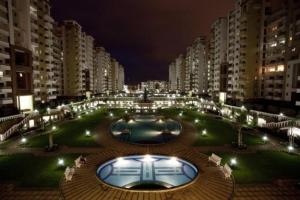 a large building with a pool in the middle of a city at Park INN Hospitality Apartment in Bengaluru