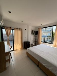 a bedroom with a bed and a desk and windows at View Theras Hotel in Doradal