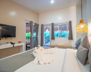 a living room with a white bed and a tv at Bathala Resort in Panglao Island
